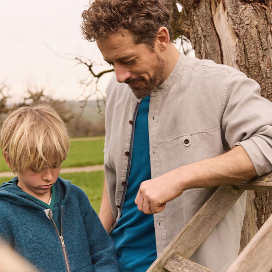 Man in T-shirt met een gieter in de tuin